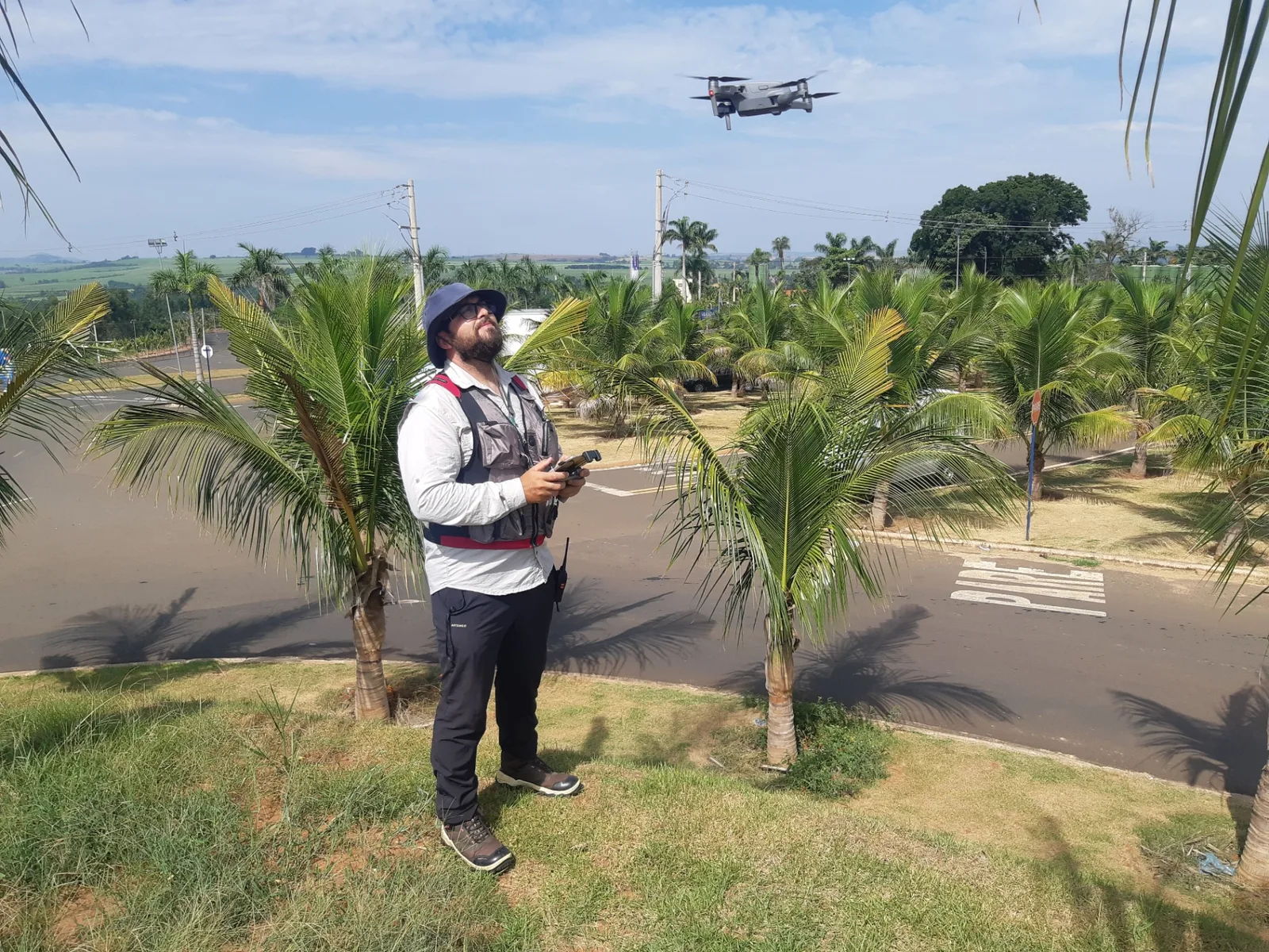 Técnico da ALG operando drone em vistoria de área urbana arborizada