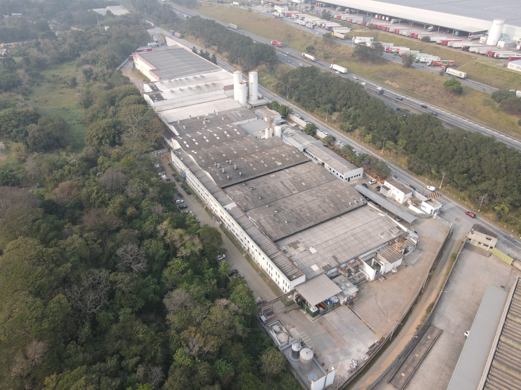 Vista aérea de complexo industrial cercado por vegetação nativa às margens de rodovia